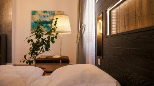 a bedroom with two beds and a lamp and a plant at Tivoli Apartament in Sebeş