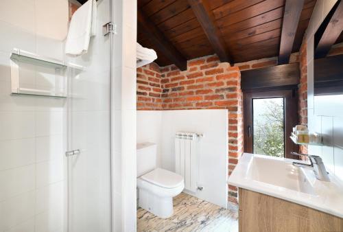 a bathroom with a white toilet and a sink at Apartamentos La Cabaña del Cerro Alto in Beceña