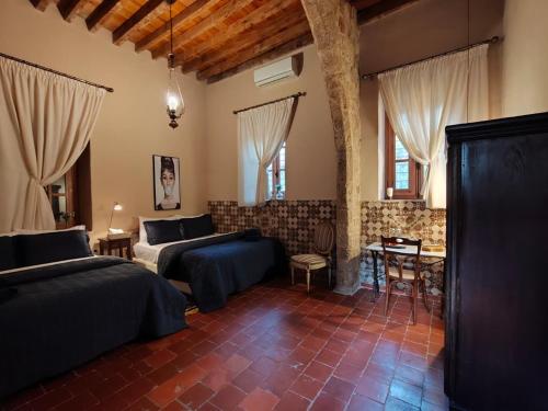 a bedroom with two beds and a table and chairs at Boutique Hotel Beit el Nessim in El Mîna