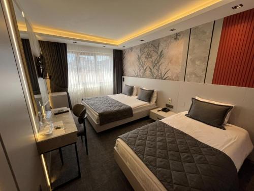 pokój hotelowy z dwoma łóżkami i biurkiem w obiekcie Starton Hotel w mieście Ankara