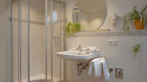 a white bathroom with a sink and a shower at Ferienwohnung Anna in Bad Kohlgrub