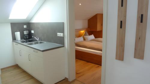 a bathroom with a sink and a bedroom with a bed at Ferienwohnung Anna in Bad Kohlgrub