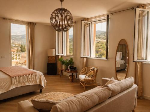 a bedroom with a couch and a bed and windows at Residenza Villa Genua in Bordighera