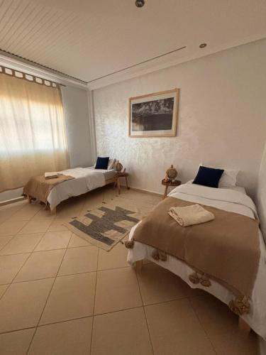 a bedroom with two beds and a window at Apartment with pool next to the ocean in Agadir nʼ Aït Sa