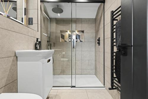 a bathroom with a shower with a toilet and a sink at Stay in Style, Two Bed! in Appleford