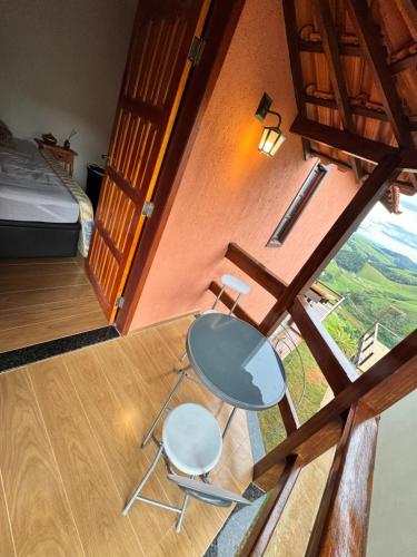 a table and two chairs in a room with a bed at Rancho Alto do Valle in Paty do Alferes