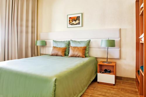 a bedroom with a large bed with two pillows at Ondamar Hotel Apartamentos in Albufeira