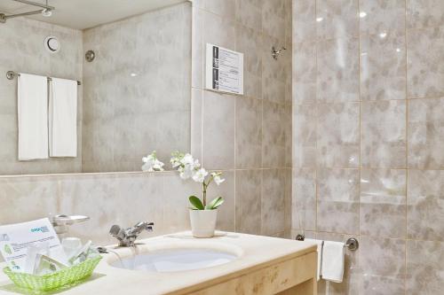 a bathroom with a sink and a mirror at Ondamar Hotel Apartamentos in Albufeira