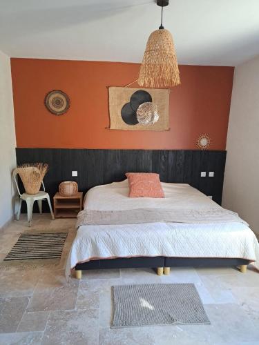 a bedroom with a bed with a red wall at Maquis in Mialet
