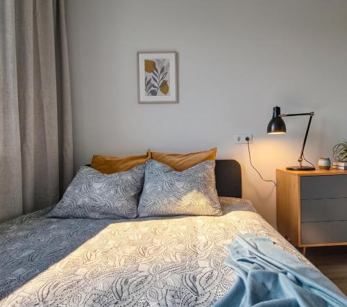 a bedroom with a bed with two pillows and a lamp at Hiiu korter Kärdlas in Kärdla