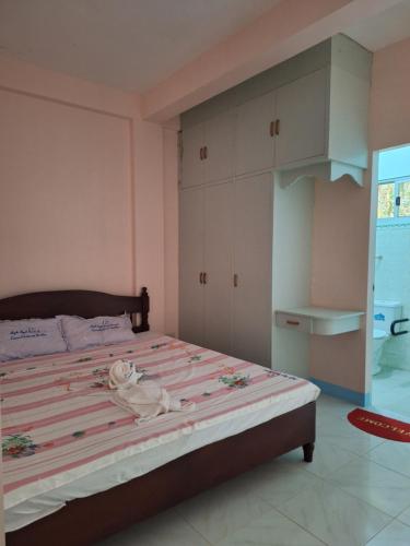 a bedroom with a bed with pink and white stripes at Ngak-Ngak Beach Resort in Calatrava