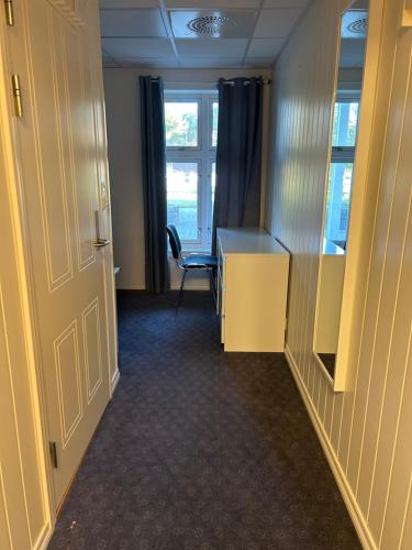 an office with a desk and a chair and a window at Fanaseter in Bergen
