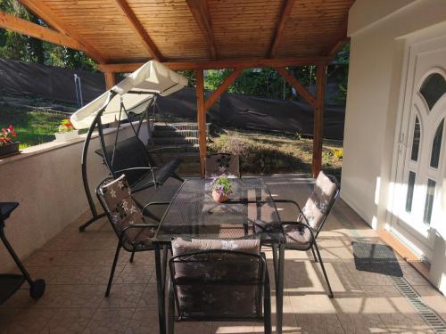 a table and chairs on a patio with a roof at Igali Kuckó in Igal