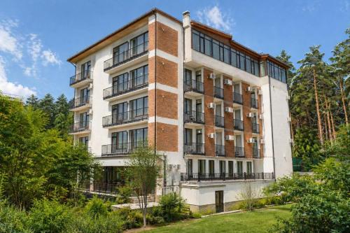 a tall brick building with a lot of windows at Emerald Borjomi Hotel in Borjomi