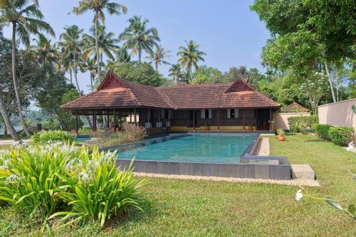 a house with a swimming pool in a yard at Vismaya by Moksha Stays in Turavūr