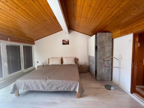 a bedroom with a bed and a wooden ceiling at Apartments Hrnjić in Umag
