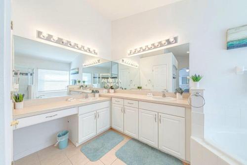 a bathroom with two sinks and a large mirror at Orlando Theme Park Pool Homes in Kissimmee