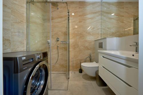 a bathroom with a washing machine and a toilet at Skyline resort CG in Budva