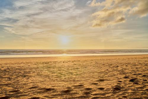 a sandy beach with the ocean in the background at Hôtel Imi Plage in Agadir