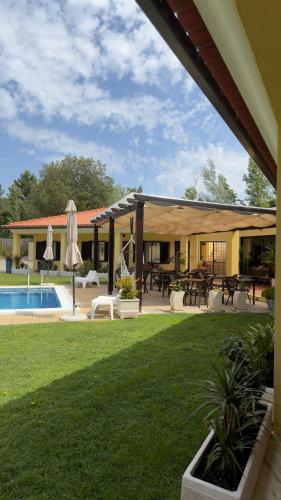 a house with a yard with a pool and a patio at Quinta Dos Amarelos Sesimbra in Sesimbra