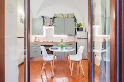 a kitchen with a table and chairs and a refrigerator at Evergreen House in Cuneo