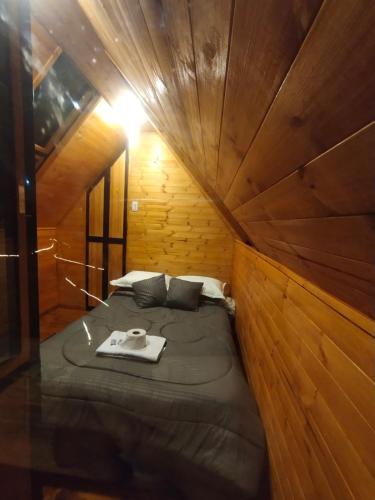 a room with a bed in a wooden cabin at Cabañas tipo glamping in Moniquirá