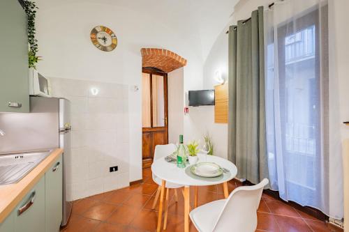 a small kitchen with a white table and chairs at Evergreen House in Cuneo