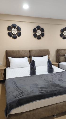 a bedroom with two beds with black blankets and flowers on the wall at jdreamboxhostelpatong in Patong Beach