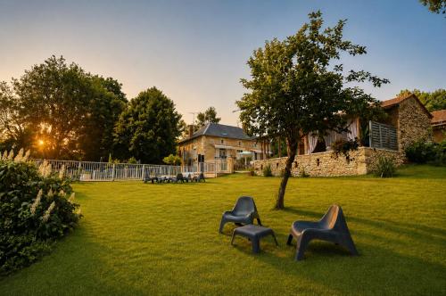three chairs sitting in the grass in a yard at La biche au bois piscine chauffee jacuzzi in Cazals