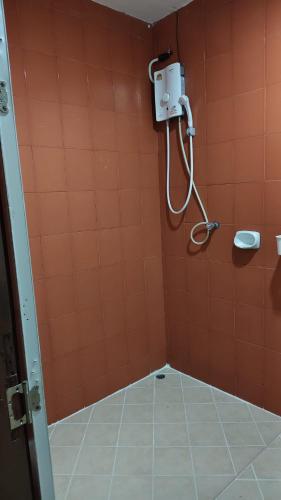 a bathroom with a shower with orange tiled walls at jdreamboxhostelpatong in Patong Beach