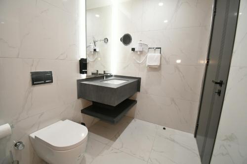 a bathroom with a sink and a toilet at Dorana Hotel Gazimagusa in Famagusta