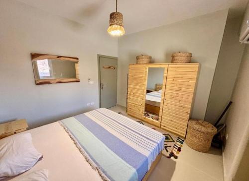 a bedroom with a bed and a wooden cabinet at Poolfront Sea View Chalet Top Rated In Dahab in Dahab