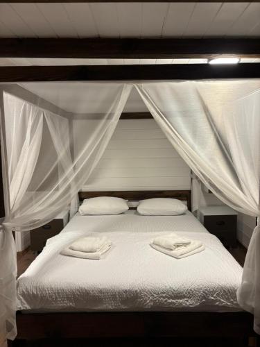 a white bed with two towels on top of it at Villa Maris in Demre