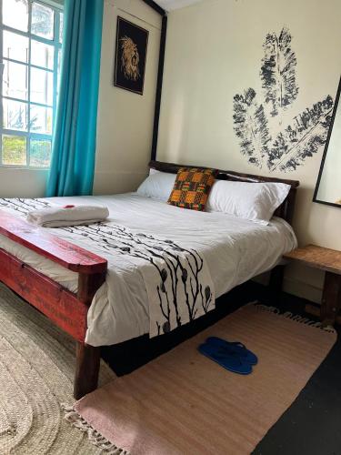 a bedroom with a large bed with a wooden frame at D's FarmStay in Kajiado