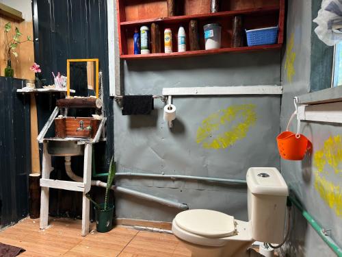 a bathroom with a toilet and a shelf at D's FarmStay in Kajiado