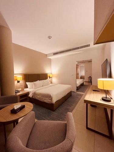 a large hotel room with a bed and a couch at Golden Tulip Amman in Amman