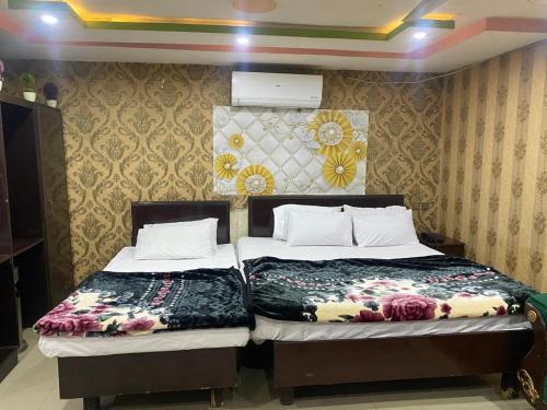 two beds sitting next to each other in a room at Hotel Lords Inn in Lahore
