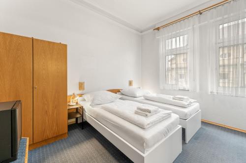 a white room with two beds and a television at Monteurapartments in Heidenheim NEU Küche Smart TV WIFI in Heidenheim an der Brenz