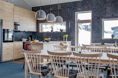 a kitchen and dining room with a table and chairs at Hemavan Mountain Lodge Storfjället in Hemavan