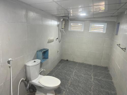 a bathroom with a white toilet in a room at Tsunami beach hotel arugambay in Pottuvil