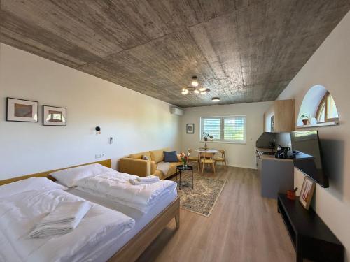 a bedroom with a bed and a living room at Apartmány u Zvonice in Kyjov