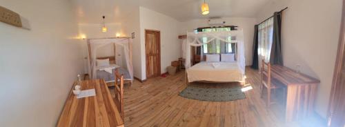 a room with a bed and a wooden floor at FRAPG camp and lodge in Mikumi