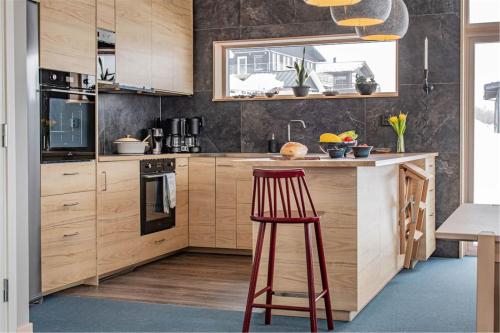 a kitchen with wooden cabinets and a red stool at Hemavan Mountain Lodge Storfjället in Hemavan