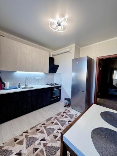 a kitchen with a stainless steel refrigerator and a table at 7 Apartmens ЖК 7-Небо Аквапарк Промринок 7 in Odesa