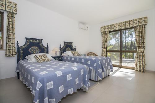 a bedroom with two beds and a window at Villa Joselina by Algarve Holidays in Vilamoura