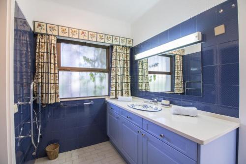 a blue bathroom with a sink and a mirror at Villa Joselina by Algarve Holidays in Vilamoura
