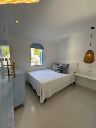 a white bedroom with a bed and a window at Casa El Eden in Puerto Triunfo