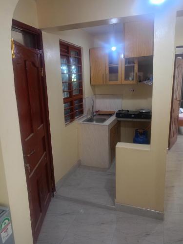 a small kitchen with a sink and a counter at Kibwezi Penthouse in Libwezi