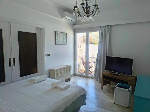 a bedroom with a bed and a flat screen tv at Nautilus andros house in Andros