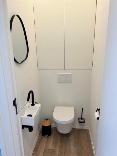 a bathroom with a white toilet and a sink at Tronc Verdi in Roeselare